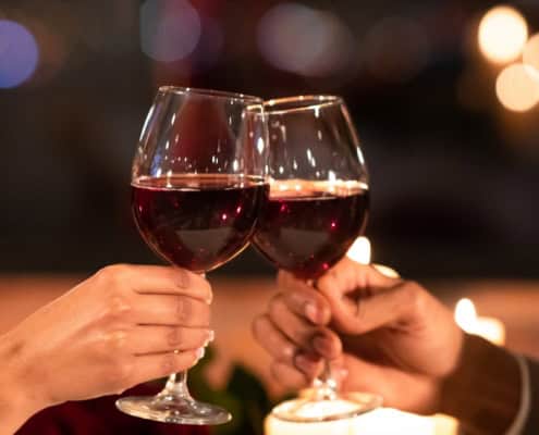 Fragen fürs erste Date: Paar stößt im Restaurant mit Gläsern an