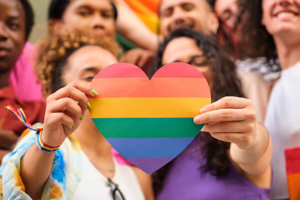 Eine Gruppe von LGBTQ-Personen mit einem Regenbogenherz zur Feier des Pride Month Liebe feiern – Vielfalt leben: Pride Month ist die Zeit für Liebe und Akzeptanz