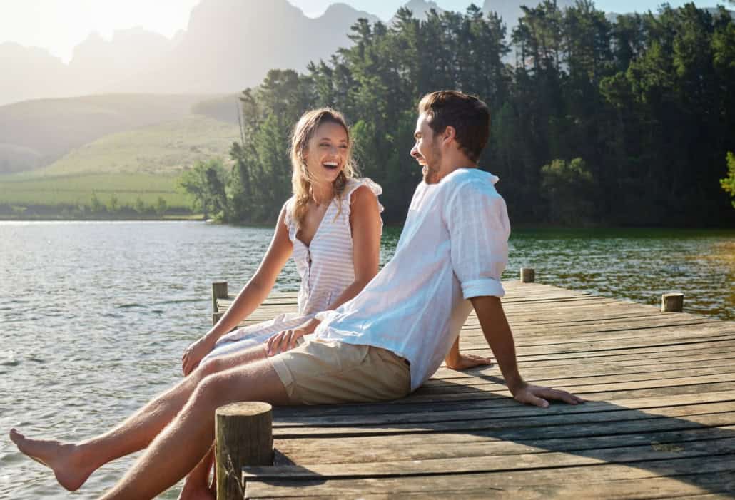 Junges Paar bei gemeinsamen Date am See Sommerromanzen, Flirts & Dates: So genießt Du die heiße Jahreszeit voller Leichtigkeit