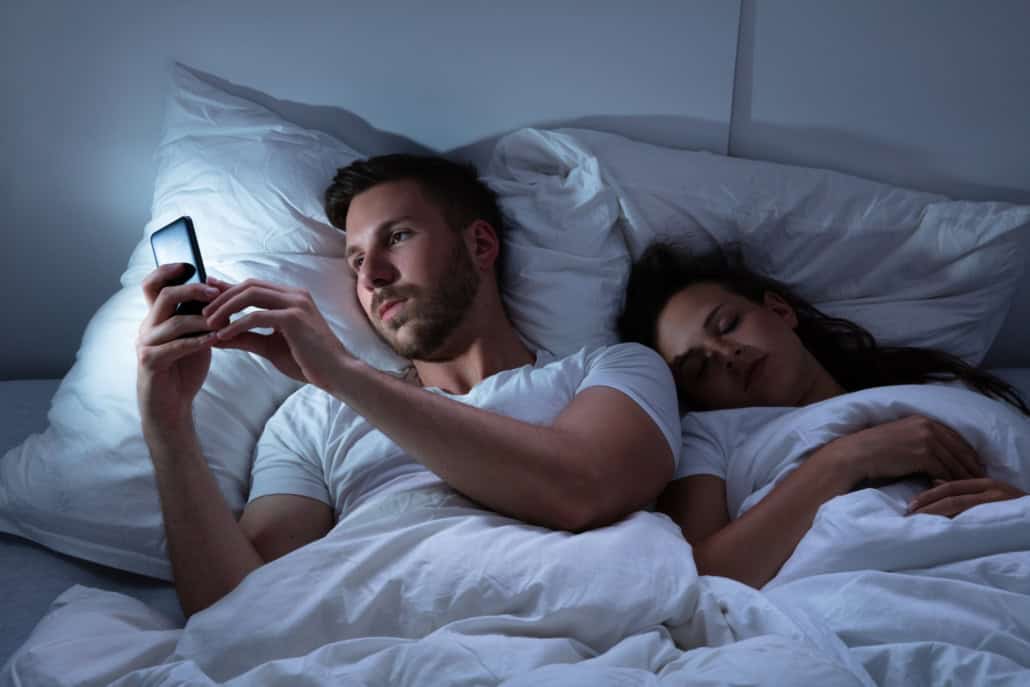Mann ist heimlich am Handy während Freundin schläft Fremdgehen: Wo fängt es an und was sind die Grenzen?