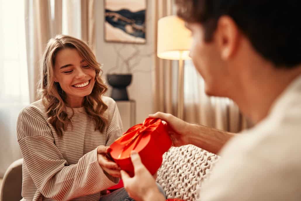 Mann übergibt seiner Freundin ein Geschenk Love Bombing: Frühwarnzeichen erkennen & gesunde Dynamiken verstehen