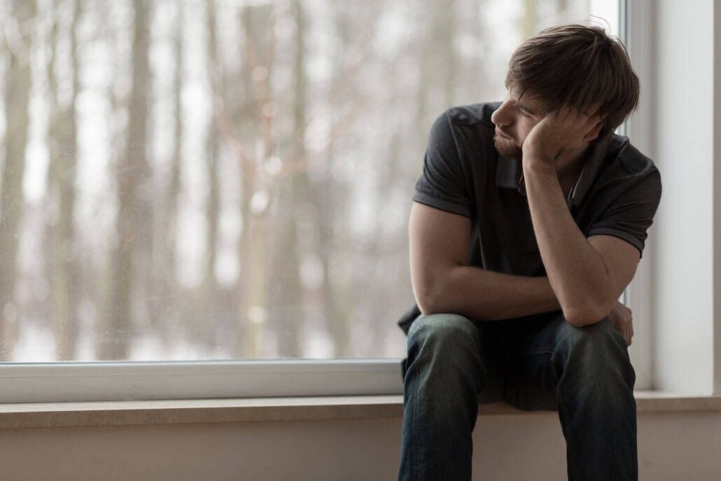 Einsamer Mann sitzt und denkt nach Bindungsangst beim Dating: Anzeichen erkennen & richtig damit umgehen